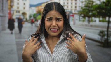 Şehir dışındaki hareketli bir sokakta duygularını ifade eden bir kadın. Geçmişi bulanık. Canlı bir ortamda şaşkın ve güvensiz duyguları somutlaştırıyor..