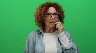 Konuşan bir kadın yeşil duvarı izole etti. Orta yaşlı esmer esmer, ciddi ifade. Sıradan bluz gözlükleri düşünceli..