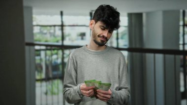 Modern bir otel ortamında elinde Rus rublesi banknotları tutan bir adam. Kapalı mekanlarda finansal işlemler sergiliyor..