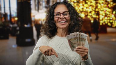 Dışarıda elinde Rus banknotları tutan ve şehir ışıklarıyla çevrili kalabalık bir caddede gülümseyen para ve finansmanı ön plana çıkaran bir kadın..