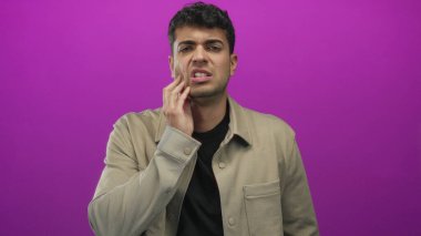 Stüdyonun arka planına dokunurken çekilen fotoğraf, genç İspanyol figürünün renkli mor duvara karşı durarak acıyı ve rahatsızlığı gözler önüne serdiğini gösteriyor..