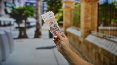 Kentin sokaklarında el ele tutuşan 1000 İzlanda kronu, şehrin arka planındaki ağaçlar ve binalarla yatırım ve para değişimi yapılmasını öneriyor.