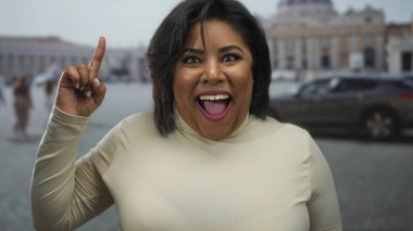 Fikir ifadeli bir kadın, bulanık mimari geçmişi olan, şehir merkezini gösteren, Vatikan 'ın St. Peter Meydanı' nı işaret ediyor..