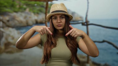 Uzun saçlı, uzun saçlı, şapkalı bir kadın açık hava manzarasını gösteriyor.