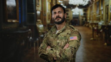 Askeri üniformalı İspanyol bir adam sanat galerisinde kültürlü bir müzeye karşı kültür tabloları ve heykeller sergiliyor..