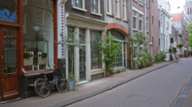 Kaldırımın kenarına parketmiş boş bir Avrupa şehir caddesi ve açık bir gökyüzünün altında tarihi binalar..