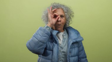 Sarı duvara yaslanmış mavi ceketli, dışlanmış arka planda anlamlı bir yüz ifadesi olan iyi niyetli bir kadın..