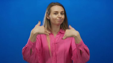 Ayrı bir mavi arka plan üzerinde güven içinde el kol hareketi yapan, parlak pembe bir gömlek giyen, açık kolları ve dostça bir ifadeyle davet ya da hoş geldin diyen bir kadın..