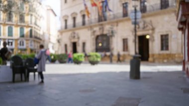 Avrupa 'nın dağılmış binaları, yürüyen insanlar ve bokeh etkisinin huzurlu şehir ortamını ve günlük yaşam ortamını yakaladığı bulanık sokak manzarası.