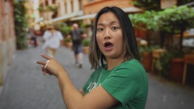 Yeşil gönüllü gömlekli kadın şehir merkezindeki açık havayı göstererek şaşırdı. Toplum faaliyetlerinde gençlik göstergesi..