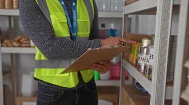 Adam kilerde not yazmadan önce pano kullanıyor. İspanyol gönüllülerin kontrol sırasında bağış envanterlerini tuttuğu bir kiler..