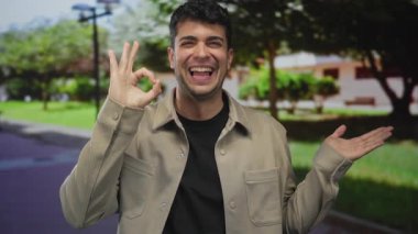 Erkekler, park manzarasını göstermek için ellerini kaldırır. Genç ve erkek, dostça bir jest göstererek dışarıda gülümserler..