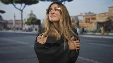 Siyah cüppeli hakim kadın Roma meydanında kollarını kavuşturuyor; yansıma dayanıklılığı yalnızlık gücü.