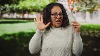 Parktaki bir kadın elinde Mısır kilosu tutarken ürkmüş görünüyor. Açık hava koşulları altında doğal yeşil bir bahçede sürpriz yapıyor..