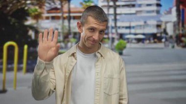 Arka planda binalar olan bir sokakta gülümseyen ve el sallayan bir adam arkadaşlığı ve bağlantıyı iletiyor..