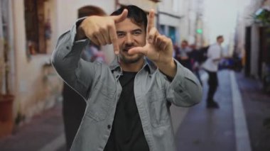 Genç İspanyol asıllı bir adam, şehir sokaklarında hareketli bir el hareketleriyle fotoğraf sanatında yaratıcılığını ve hareketliliğini gösteriyor..