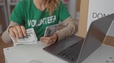 Sarışın genç bir kadın, bağış için gönüllü olarak para sayarken el ele tutuşuyor..