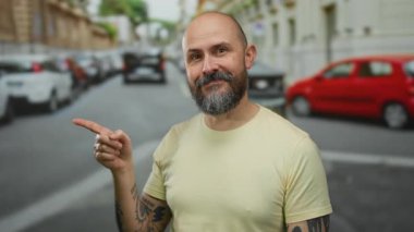 Güneşli bir günde, arka planda arabalar ve binalarla gülümseyen sakallı kel bir adam, büyüleyici bir şehir manzarası yaratıyor..