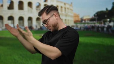 Roma Kolezyumu 'nun önünde gülümseyen ve sunan sakallı genç adam güneşli gökyüzünün altında tarihi Roma' nın özünü yakalıyor..