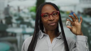 Terasta elinde ethereum para tutan kadın gözlük takıyor. Modern finans ve teknoloji bağlantısını gösteriyor..