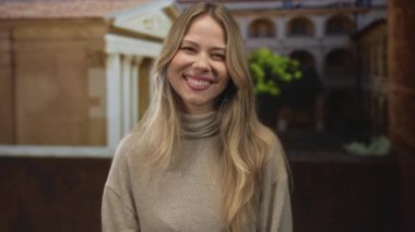 Kampüs manastırındaki taş kemer yoluna başını hafifçe eğen kadın dudaklarını büzüyor; oyun merakı entrika eğlencesi.