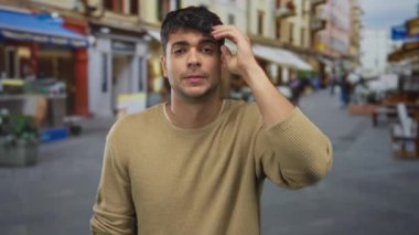 Adam meşgul bir caddede genç bir İspanyol erkek kentsel enerjisiyle facepalm yapmak için elini kullanıyor..