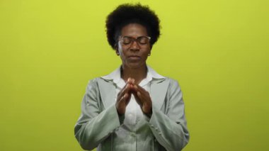 İzole edilmiş sarı arka planda gülümseyen kadın, huzuru, rahatlığı, maneviyatı, pozitifliği, farkındalığı, gençlik sükunetini ve odaklanmayı ön plana çıkarıyor..