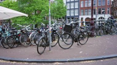 Amsterdam 'ın geleneksel kanal evlerinin önüne parketmiş bisikletler, bulanık odak ile Hollanda' nın canlı kentsel manzarasında bir bokeh etkisi yaratıyor.