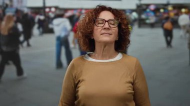 Farklı yayaların dikkat çeken varlıkları arasında sakin bir meditasyon yapan bir kadın..