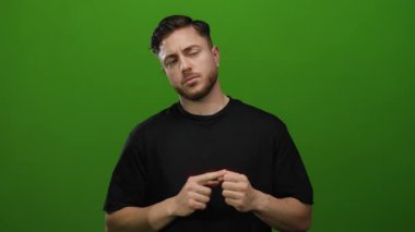 Sakallı genç adam, izole edilmiş yeşil duvara karşı parmaklarını sayıyor..