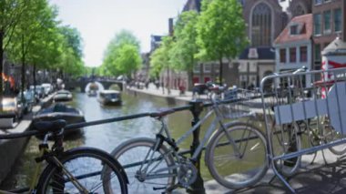 Bisikletler Amsterdam 'da bulanık ağaçlar ve kayıklarla dolu bir kanal oluşturarak sakin bir şehir manzarası yaratıyor..