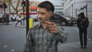 Genç bir adam kentin kalabalık caddesinde, hareketli ve dinamik bir açık hava sahnesini yakalar ve güvenli bir şekilde gülümser..