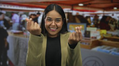 Kadın, dükkanın yoğun atmosferinde Latin ispanyol tebessümüyle pazarda el ele tutuşup para veriyor..