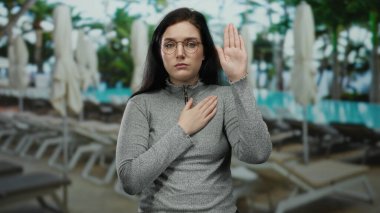 Kadın, yüzme havuzunu ciddi bir ifadeyle kurarak, açık havada barışçıl bir ortamda samimiyet ve bağlılık göstererek yemin ediyor..