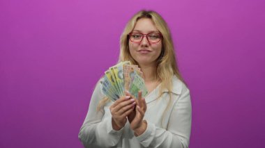 Romanyalı banknotları olan bir kadın canlı pembe bir arka plana güvenle gülümsüyor, renkli para birimiyle izole bir ortamda finans ve zenginlik sergiliyor..