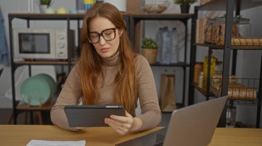 Modern ofiste raflar, dizüstü bilgisayarlar ve kağıtlarla tablet üzerinde çalışan bir kadın, kızıl saçlı estetik bir profesyonel ortam sunuyor..