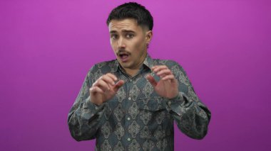 İspanyol desenli gömlekli genç adam, tecrit edilmiş pembe bir duvardan korkmuşa benziyor..