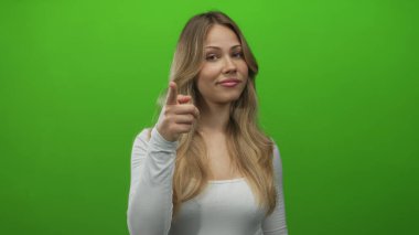 Uzun kollu beyaz kollu sarışın kadın, stüdyoda işaret parmağı olan tapınağa dokunuyor..