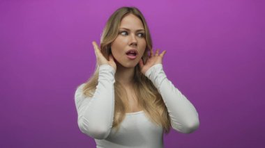 Sarışın kadın, canlı mor duvara karşı fotoğraf stüdyosunda dikkatlice dinliyor. Merakın dikkat karışıklığı konsantrasyonu..