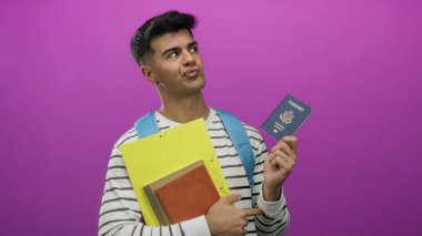 Çizgili gömlekli genç adam bize pasaport ve dokümanlar veriyor. Canlı pembe arka plan, seyahat ya da kimlik teması öneriyor. Meraklı ve düşünceli bir ifade sergiliyor..