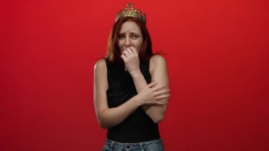 Taçlı bir kadın endişeli bir ifadeyle canlı kırmızı arka planda, karşıt duygular sergiliyor kraliyet ve kaygı.