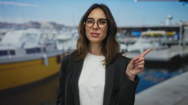 Deniz kıyısında duran İspanyol kadın açık havada gökyüzü altında teknelerle çevriliyken bir noktayı vurguluyor..