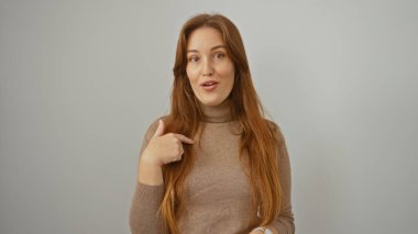 Beyaz bir arkaplan karşısında, şaşırmış bir ifadeyle kendini gösteren bir kadın..