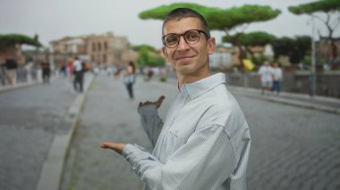 Gözlüklü bir adam ünlü İtalyan caddesinde insanlarla el kol hareketi yapıyor. Roma 'nın tarihi kaldırım taşı ayininde güneşli bir günde canlı bir şehir hayatı sergiliyor..