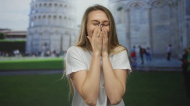Pisa kulesine yaslanmış gülümseyen bir kadın, İtalya 'da kaygısız enerjiyle neşeli bir açık hava seyahati anını yakalıyor..