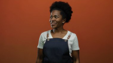 Önlük giyen kadın, izole edilmiş kırmızı arka plana karşı duruyor..