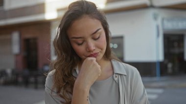 Sokakta gezen genç bir kadın şehir ortamında düşünce ifadesini sergiliyor..