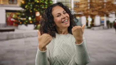 Kış süveteri içinde açık havada kışın gülümseyen kıvırcık saçlı bir kadın..