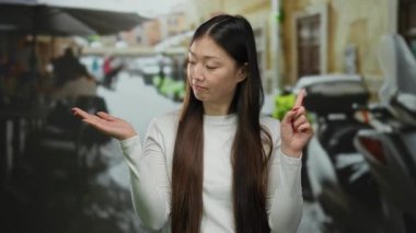 Şehir terasında açık avuçla onaylamadığını ifade eden bir kadın, açık şehir restoranlarında hayır diyor, genç bir kadının gelişigüzel varlığını gösteriyor..