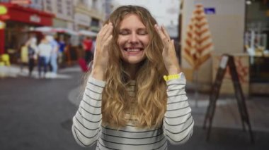 Kadın şaşırmış sokak sarışının genç gülüşü. Açık hava portresi neşeli bir tepkiyi yakalıyor..